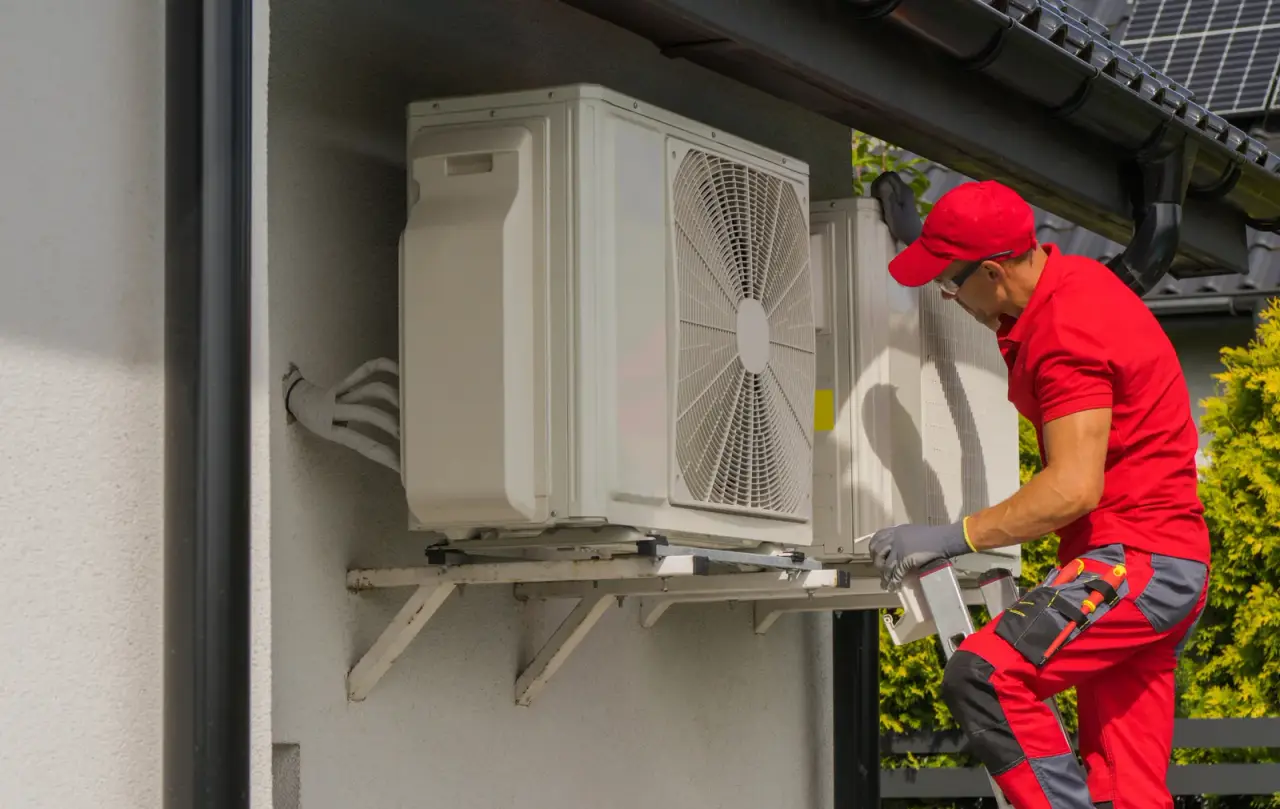 HVAC technician installing air conditioning unit on wall