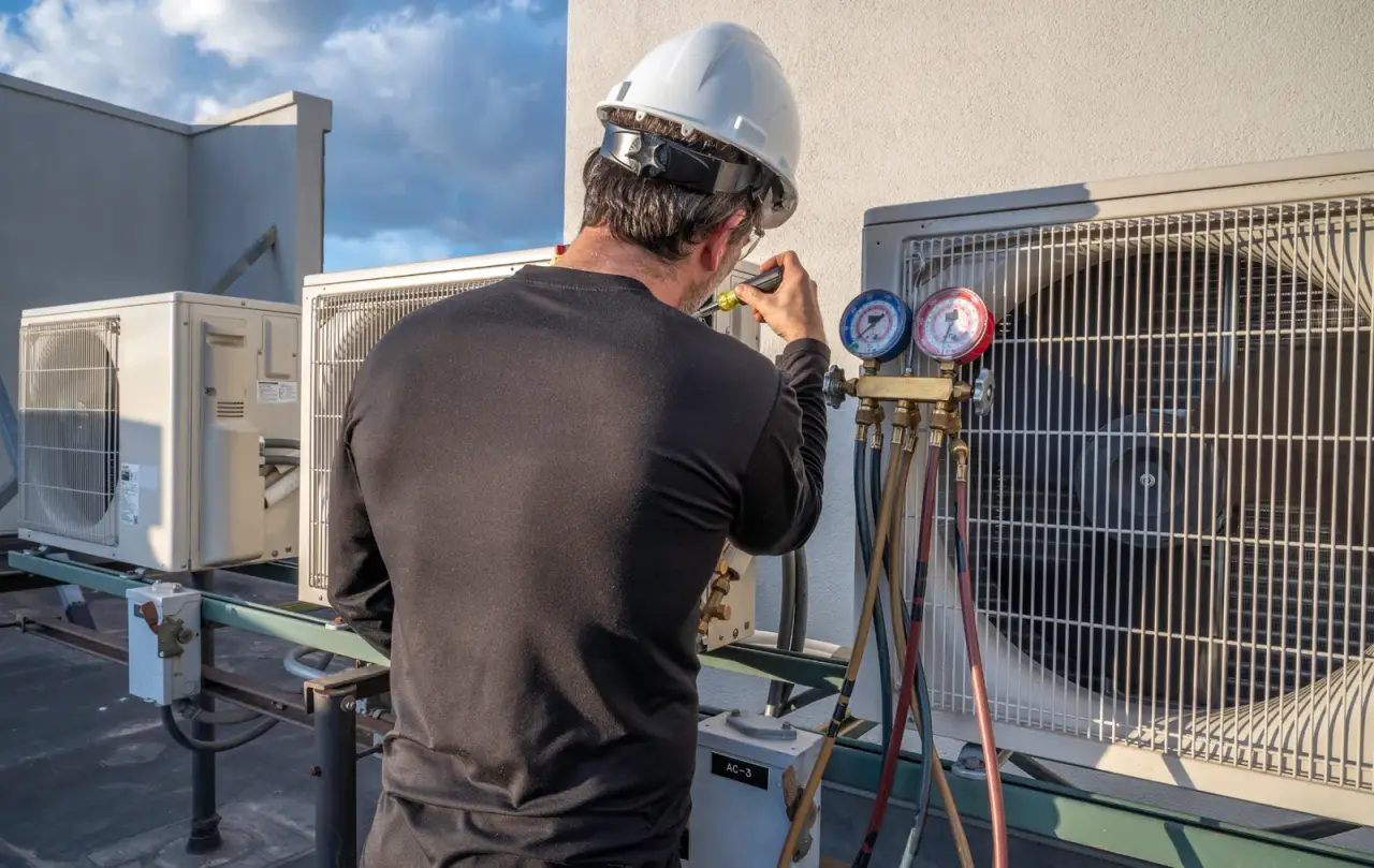 HVAC technician on rooftop servicing air conditioning units